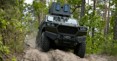The Inguar-3 armored vehicle driving through a soil pathway with a forest background