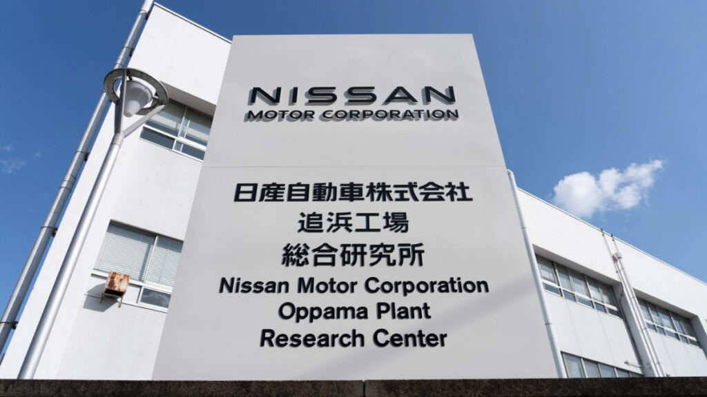 A building signage of Nissan Motor's Oppama plant with black writing.